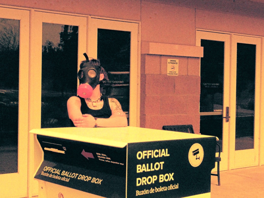A faggot wearing a gas mask leaning on a ballow box.
