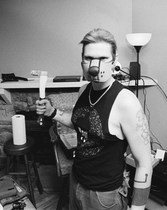 A faggy pup looks at the camera while holding a hog-slapping hammer.